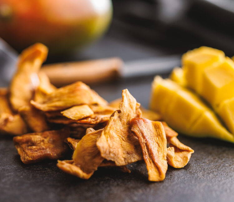 Dried mango fruit on the black table.