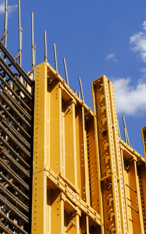 The exterior of a construction site, a high rise building, rebar concrete shuttering and metal mesh grids for building.